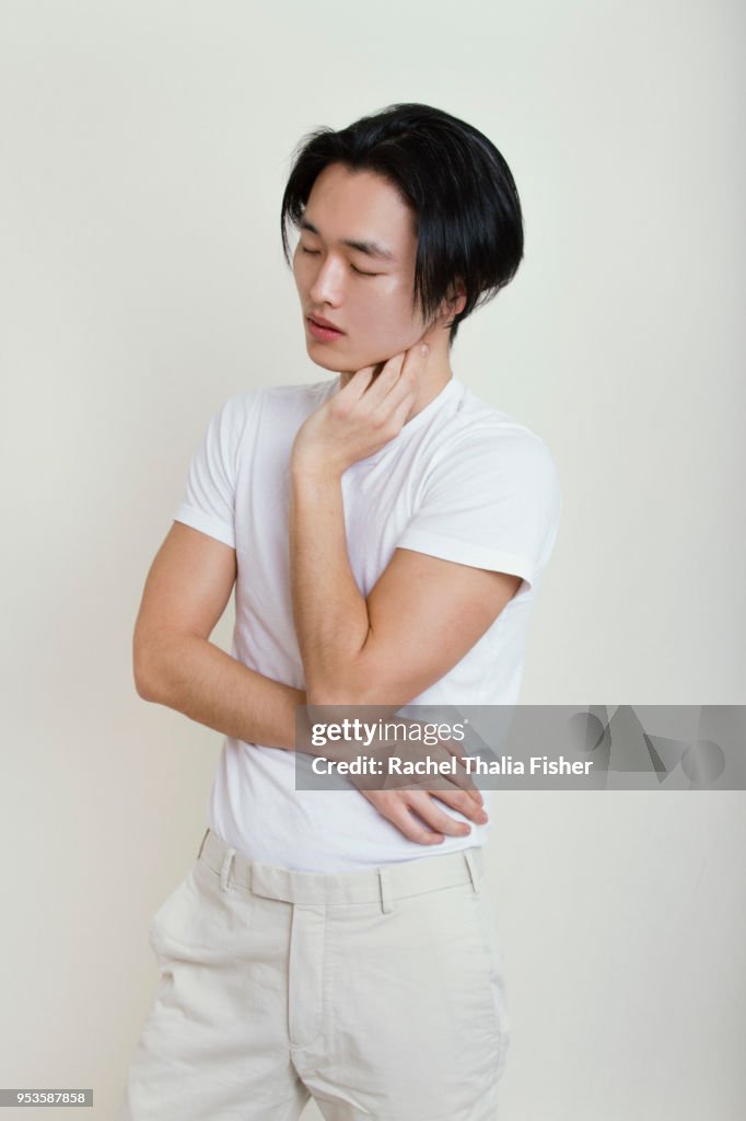 Asian man looking pensive in studio portrait