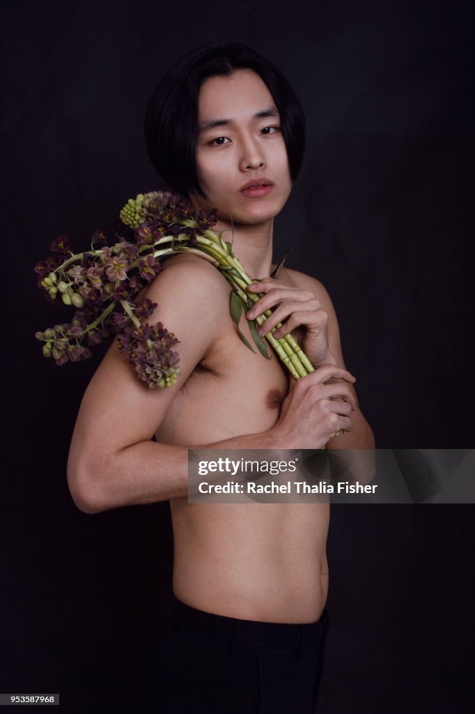 Korean young adult male in studio holding flowers