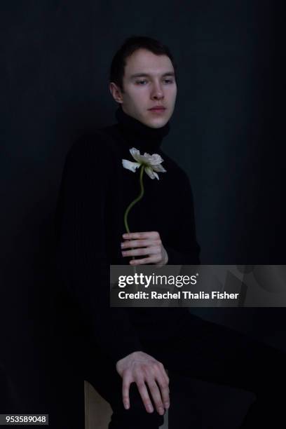 Portrait of young man in studio holding flower