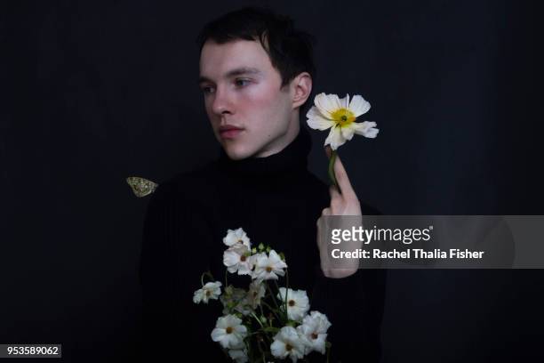 Portrait of young male holding flowers in both hands