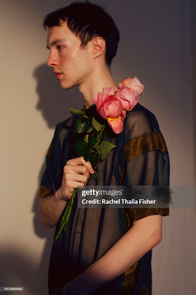 Man holding pink roses in studio