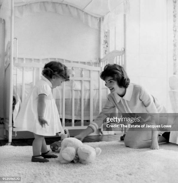 In the nursery of their Georgetown home , Jacqueline Kennedy plays with her daughter Caroline, Washington DC, late 1950s.