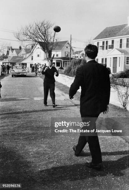 Attorney General Robert F Kennedy keeps his eys on a football thrown by his brother, lawyer Ted Kennedy , on a residential road, Hyannis Port,...