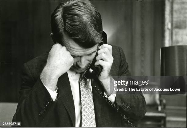 View of US Attorney General Robert F Kennedy , one hand on his head and a telephone in the other, as he listens, his head bowed down, early 1960s.