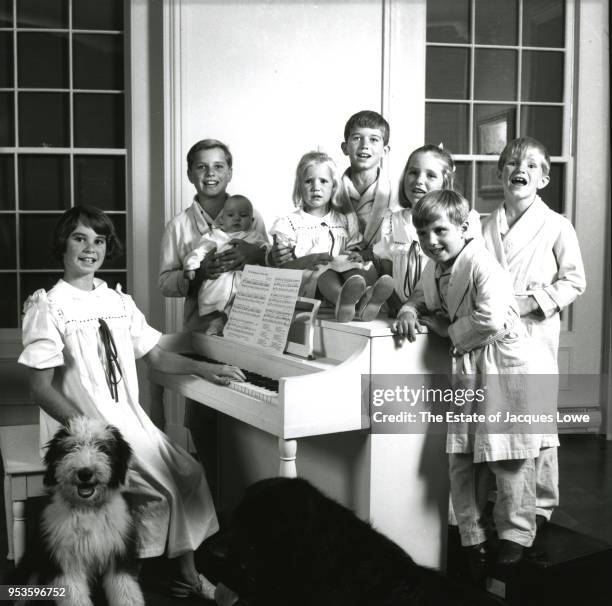 Portrait of the children of Robert and Ethel Kennedy, all dressed in pajamas or nighgowns, as they pose around a piano, late 1963. Pictured are, from...