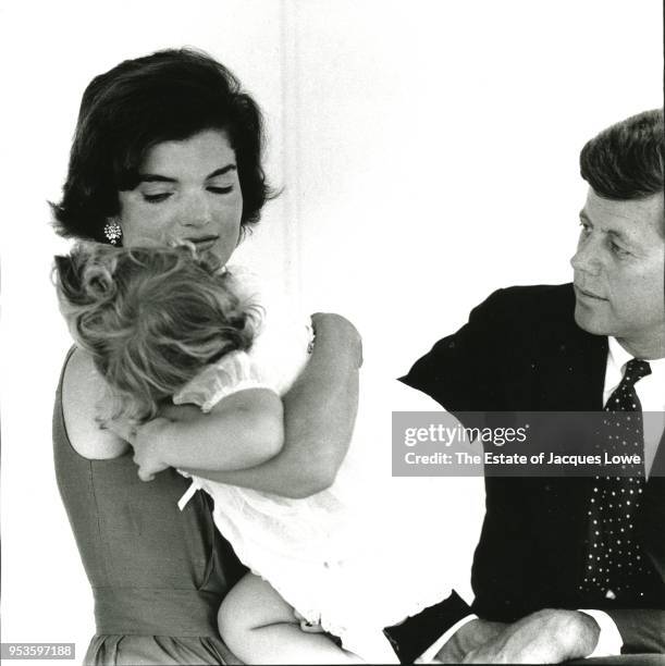 Portrait of married couple Jacqueline Kennedy and Senator John F Kennedy as they pose with their daughter Caroline, Hyannis Port, Massachusetts,...