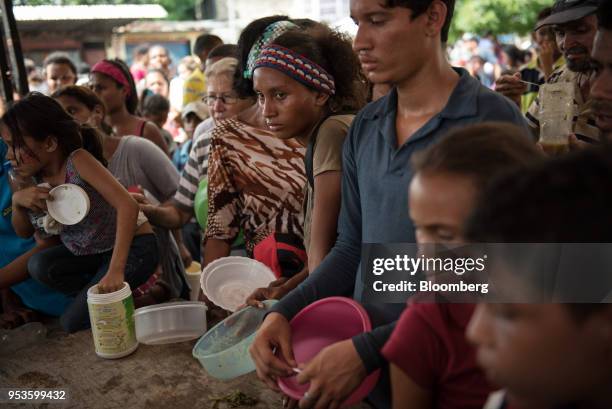 People wait to fill their containers with complimentary soup during a campaign rally for presidential candidate Javier Bertucci on International...