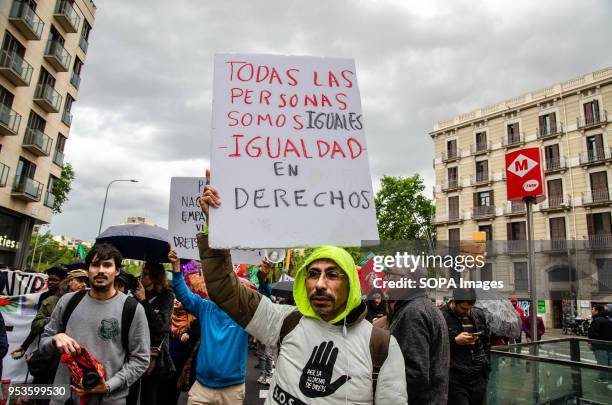 Protester is seen with a sign with the text "all people are equal. The same rights" during the demonstration against job insecurity in Barcelona. As...