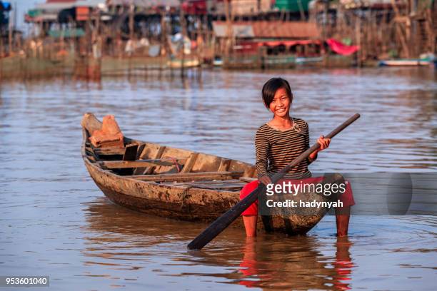 cambodian little girl rowing a boat, tonle sap, cambodia - cambodian ethnicity stock pictures, royalty-free photos & images