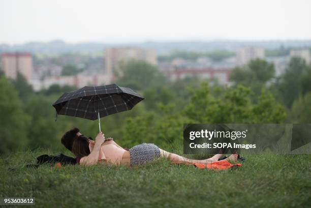 Couple protects themselfs during a rain storm at Zakrzowek lake in Krakow. Zakrzowek lake was created in 1990 after flooding an old limestone quarry...