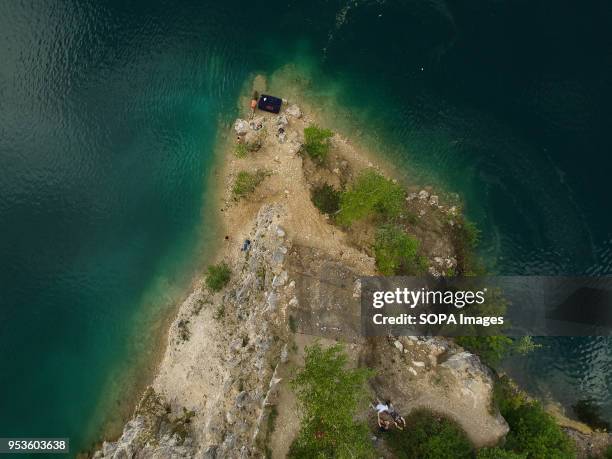 People stand in the rocks at zakrzowek lake in Krakow. Zakrzowek lake was created in 1990 after flooding an old limestone quarry . It consists of two...