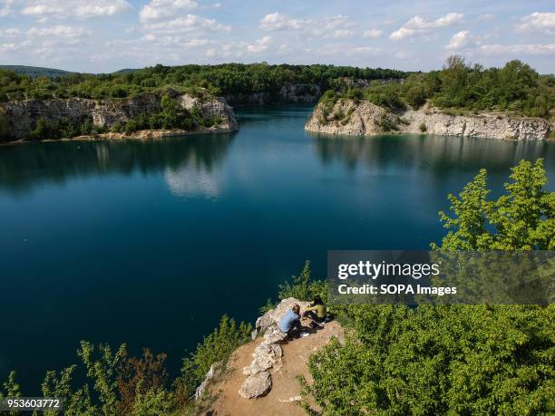 Two girls enjoy a sunny day at Zakrzowek lake in Krakow. Zakrzowek lake was created in 1990 after flooding an old limestone quarry . It consists of...