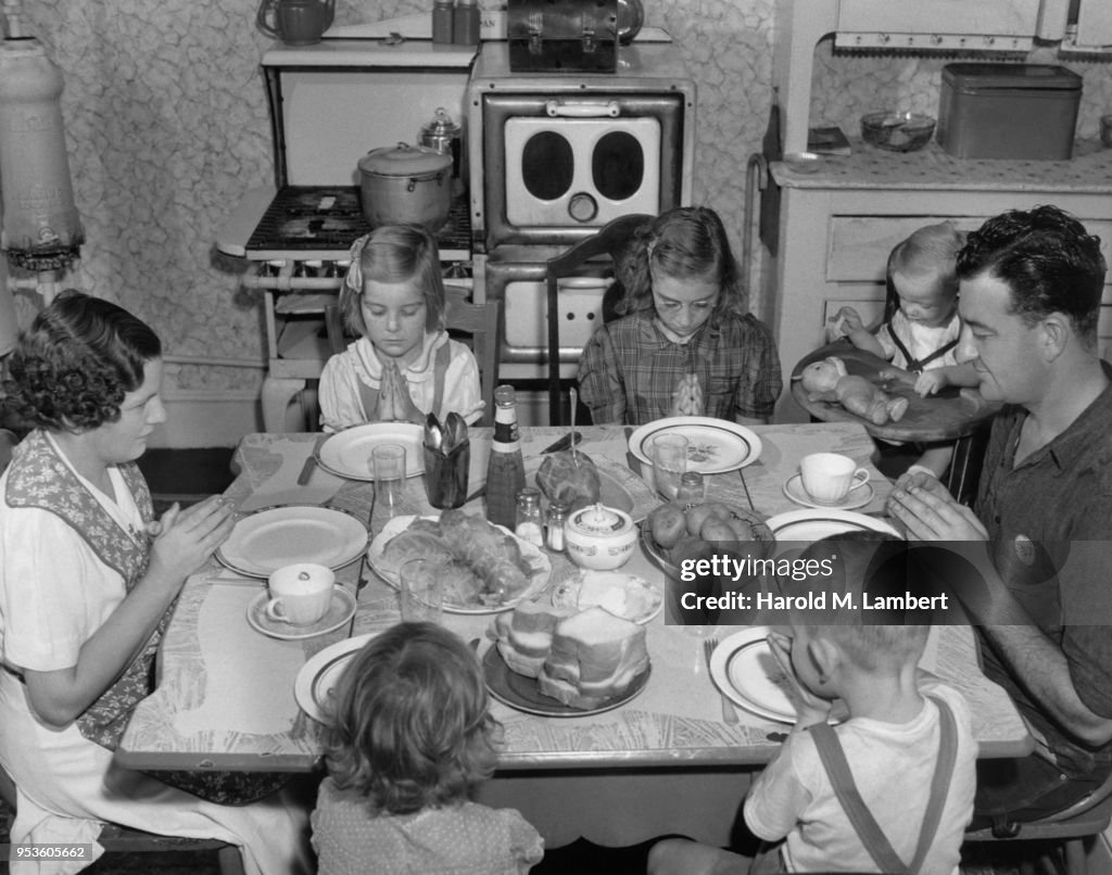 FAMILY PRAYING BEFORE HAVING MEAL