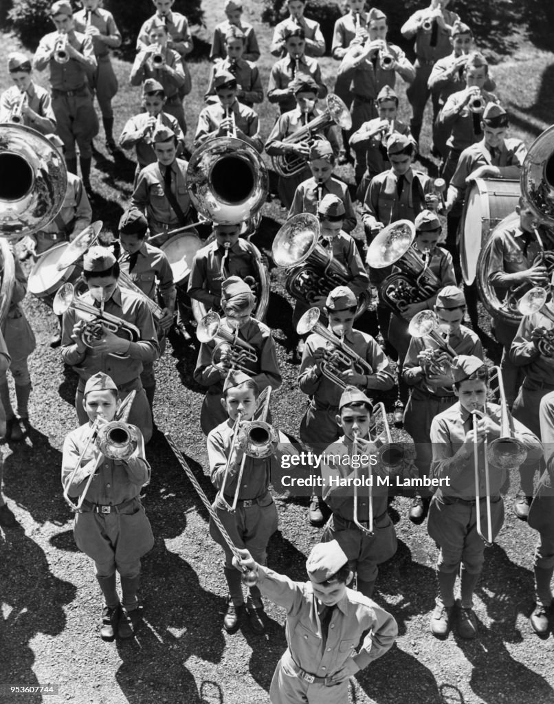 GROUP OF CHILDREN PLAYING MUSICAL INSTRUMENTS IN MARCHING BAND