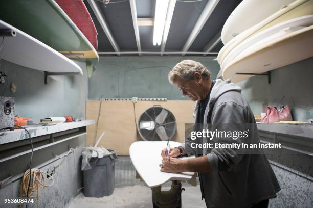 mature man making a surfboard in his workshop - moulding a shape stock pictures, royalty-free photos & images