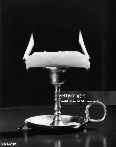 CANDLE ON STAND BURNING AT BOTH ENDS