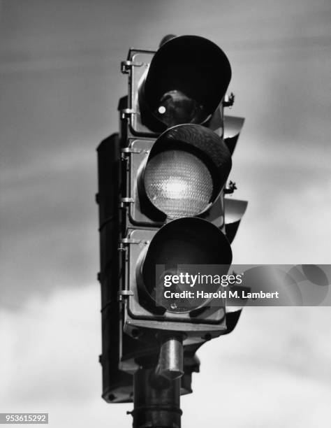 LOW ANGLE VIEW OF YELLOW TRAFFIC LIGHT AGAINST SKY