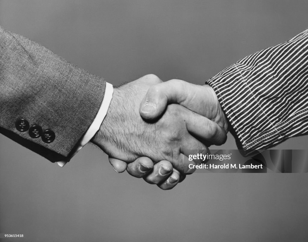 CLOSE-UP OF PEOPLE SHAKING HANDS