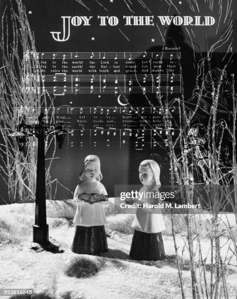 COMPOSITE IMAGE OF CAROL SINGER FIGURINES AND MUSIC SHEET