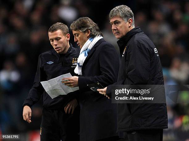 Roberto Mancini manager of Manchester City gives instructions to Craig Bellamy as his assistant, Brian Kidd looks on during the Barclays Premier...