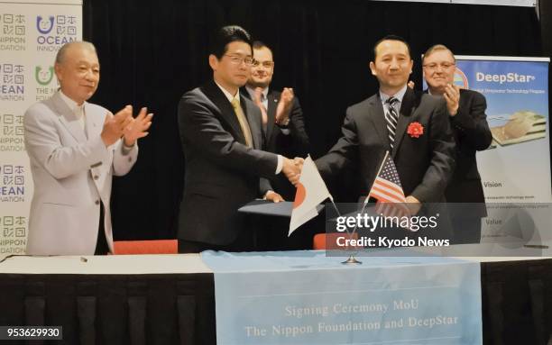 Senior officials of Japanese nonprofit organization The Nippon Foundation and U.S. Consortium DeepStar shake hands in Houston after signing a deal to...