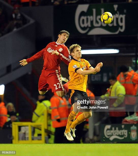 Emiliano Insua of Liverpool goes up with Kevin Doyle of Wolverhampton Wanderers during the Barclays Premier League match between Liverpool and...