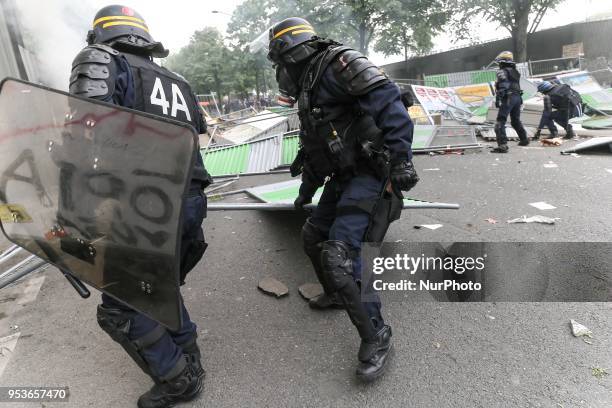 Anti-riot policemen remove a burning barrier during a demonstration on the sidelines of a march for the annual May Day workers' rally in Paris on May...