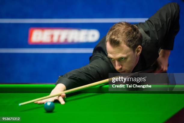 Judd Trump of England plays a shot in the quarter-final match against John Higgins of Scotland during day eleven of the World Snooker Championship at...