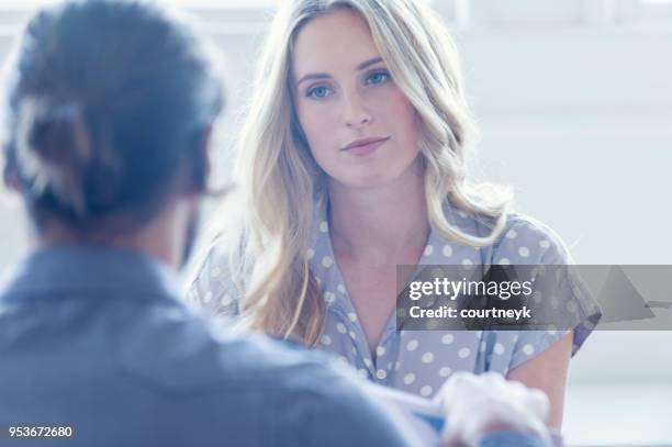 sie sind beide junge geschäftsleute lässig gekleidet in einem hellen büro. - woman talking doctor stock-fotos und bilder