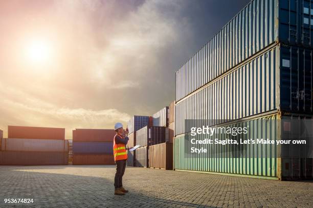 smart engineer foreman control loading containers box from cargo freight ship for import export. business logistic and transportation concept - dock worker stock-fotos und bilder