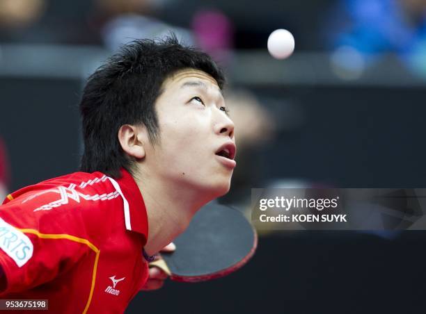 Japan's Jun Mizutani eyes the ball as he plays against German's Zoltan Fejer-Konnerth during their men's singles 3rd-round match at the 2011 World...