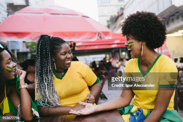 brazilian women celebrating in a street bar - moving down to seated position stock pictures, royalty-free photos & images