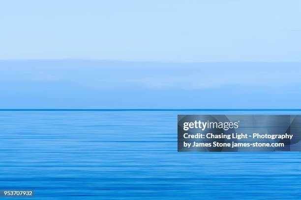 calm blue sea leading to blue sky at horizon - maritime photos et images de collection
