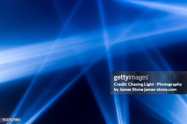 blue spotlights shining into a starry sky - floodlight stockfoto's en -beelden