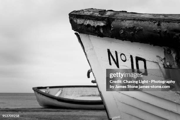 pair of rustic rowing boats - season 10 stock-fotos und bilder