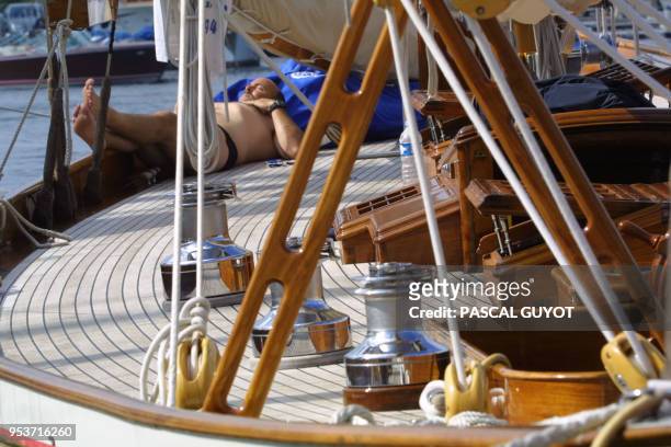 Un homme d'équipage d'un yacht de tradition fait la sieste entre deux régates sur son bateau amarré dans le vieux port de Saint-Tropez, le 02 octobre...