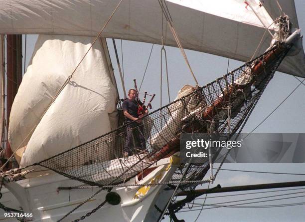 Un homme joue de la cornemuse sur un bateau arrivant dans le baie de Douarnenez, le 12 août, pour participer au grand rassemblement de vieux...