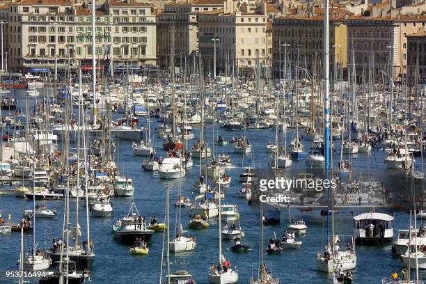 Le catamaran Club Méd , barré par le co-skipper Franck Proffit, suivi de nombreux plaisanciers, sort du Vieux Port, le 31 mars 2001 à Marseille, lors...