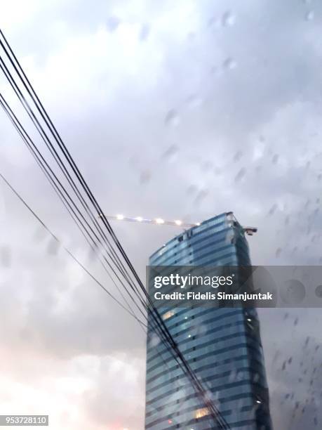 jakarta skyscraper  anf electricity cable viewed through a wet window - anf stock pictures, royalty-free photos & images