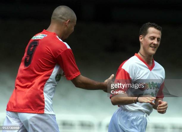 Racing pilot Michael Schumacher of Germany is greeted by Brazilian soccer player Ronaldo, 28 March 2001 during a friendly match for the UNICEF in...