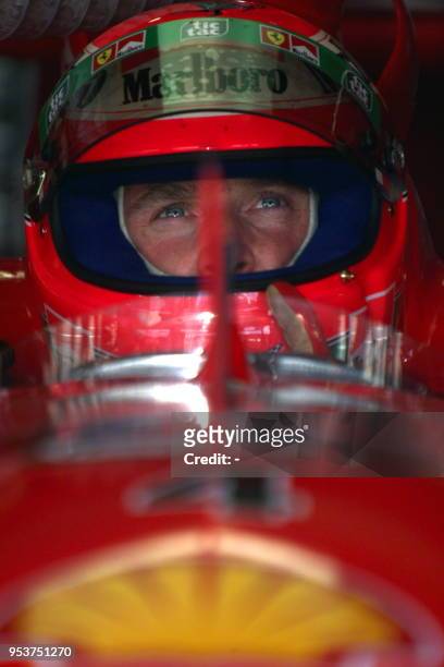 Irish Ferrari driver Eddie Irvine seats in his car in the pits during the second free practice session, 30 July 1999 on the Hockenheim racetrack two...