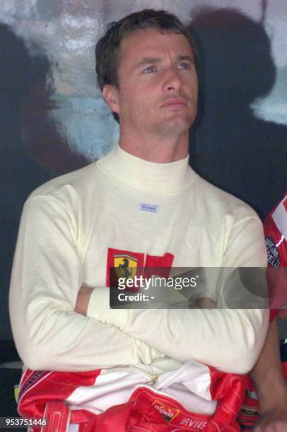 Irish Ferrari driver Eddie Irvine looks pensive in the pits of the Silverstone racetrack, 09 July1999 during the first free practice session, two...