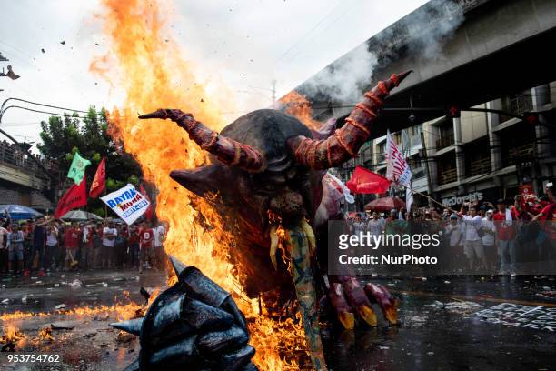 An effigy depicting President Rodrigo Duterte as a demon with metal hands burns after being set on fire by Filipino protesters during a protest on...