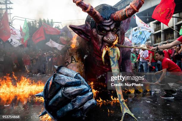 An effigy depicting President Rodrigo Duterte as a demon with metal hands burns after being set on fire by Filipino protesters during a protest on...