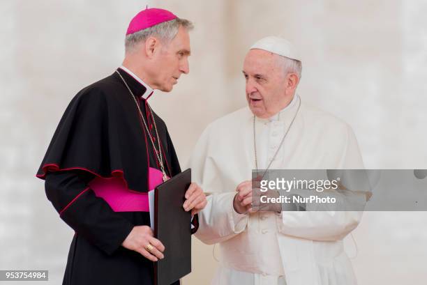 Pope Francis shares a word with Prefect of the Papal Household Georg Ganswein, left, during his weekly general audience, in St. Peter's Square, at...