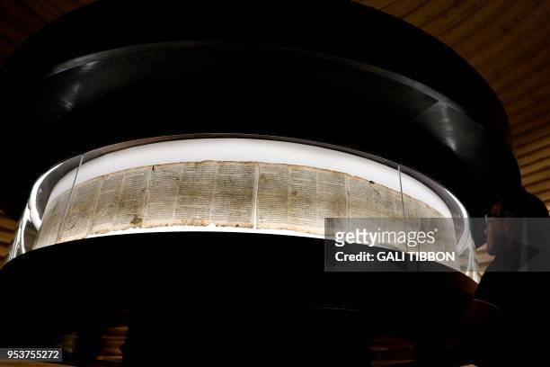 Man looks at the Dead Sea Scrolls found in Qumran caves in the Judean Desert and dated around 120 BC, during a visit to the Shrine of the Book at at...