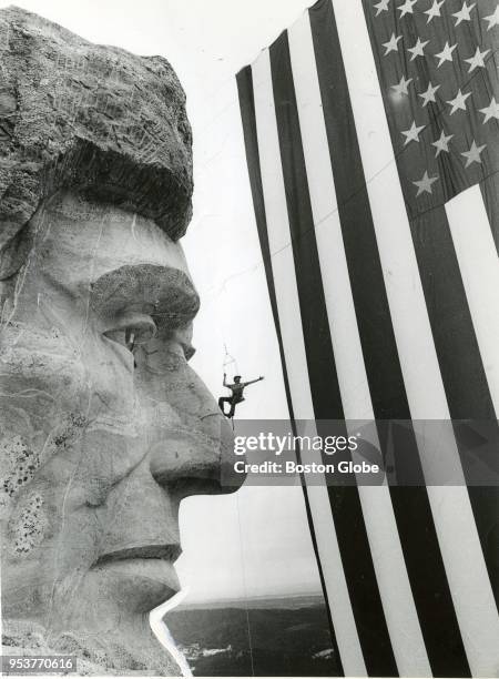 Bob Crisman attaches a flag to Lincoln for the Mount Rushmore National Park Fourth of July ceremony in Keystone, S.D., July 4, 1987. The 50th...