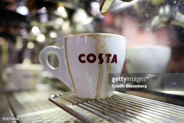 An espresso cup sits on the grille of a coffee making machine in a Costa Coffee shop, operated by Whitbread Plc, in London, U.K., on Wednesday, May...