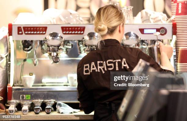 Barista uses a coffee machine to froth a container of milk behind the counter of a Costa Coffee shop, operated by Whitbread Plc, in London, U.K., on...