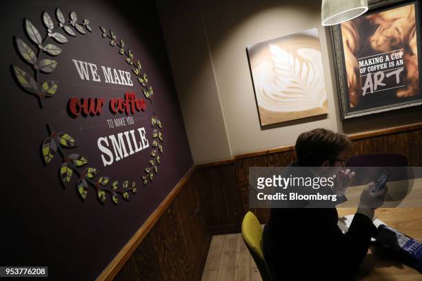 Customer browses a smartphone device in a Costa Coffee shop, operated by Whitbread Plc, in London, U.K., on Wednesday, May 2, 2018. Whitbread is...